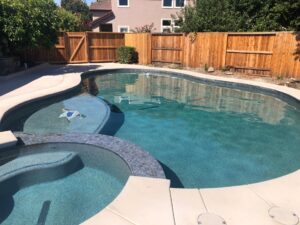 Level 2 pool and spa, 4' radius spa with negative edge, 22,000 gallon pool, Tahoe blue mini pebble. This pool was completed in 35 days.